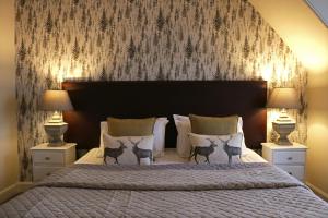 a bedroom with a large bed with two lamps at No12 Hotel in North Berwick