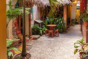 eine Terrasse mit einem Tisch, Stühlen und Pflanzen in der Unterkunft Flying Dog Hostel Iquitos in Iquitos