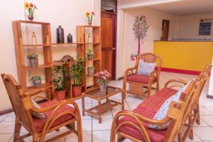 Flying Dog Hostel Iquitos في إكيتوس: غرفة معيشة مع كراسي وطاولة بالنباتات