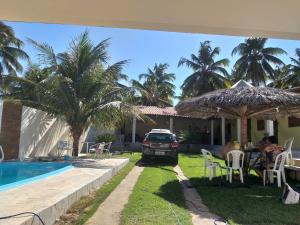 CASA DE PRAIA NO MIAI DE CIMA, CORURIPE 90 metros da praia في كوروريبي: سيارة متوقفة أمام منزل به مسبح