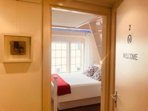 een kleine slaapkamer met een bed en een raam bij Little Tulip in Amsterdam