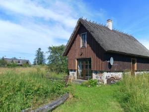 an old barn with a roof on a field at Rukkilille Holiday Home in Pärsama