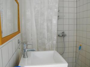 a white sink in a bathroom with a shower at Rukkilille Holiday Home in Pärsama +29 photos