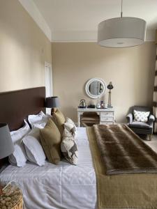 a bedroom with a large white bed and a mirror at No12 Hotel in North Berwick