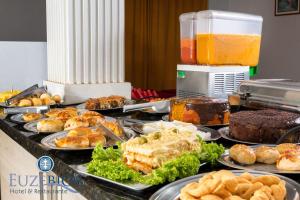 a buffet filled with different types of food on plates at Hotel Euzebio´s in Boa Vista
