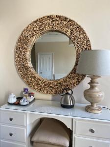a mirror on top of a white dresser with a lamp at No12 Hotel in North Berwick