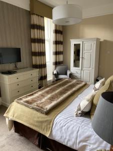 a bedroom with a bed with a large blanket on it at No12 Hotel in North Berwick