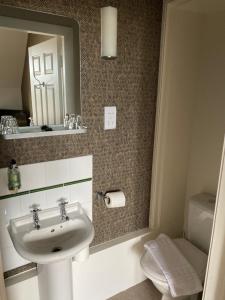 a bathroom with a sink and a mirror and a toilet at No12 Hotel in North Berwick