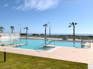a large swimming pool with palm trees in the background at appartement Duna Beach in Torrox Costa