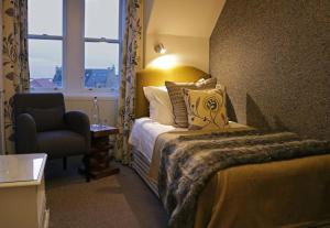 a hotel room with a bed and a chair and a window at No12 Hotel in North Berwick