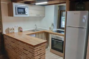 uma cozinha com um frigorífico branco e um lavatório em Casa en La Rinconada em El Barraco