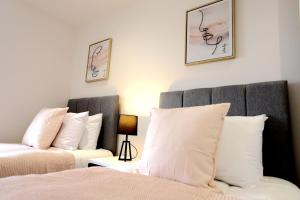 a bedroom with two beds with white pillows at Birmingham NECAirport Interchange shortstay homebase in Birmingham