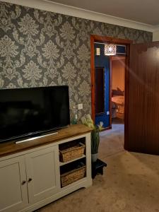 a living room with a flat screen television on a cabinet at 2 Raasay Court in Portree