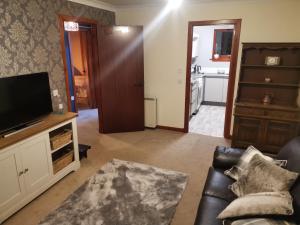 a living room with a couch and a television at 2 Raasay Court in Portree