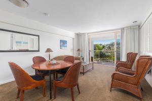 uma sala de estar com mesa e cadeiras em Charlesworth Bay Beach Resort em Coffs Harbour