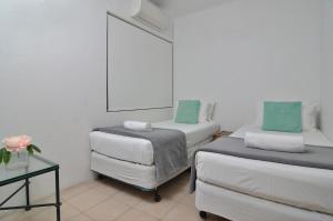 a small room with two beds and a table at Seascape Holidays - Driftwood Mantaray in Port Douglas