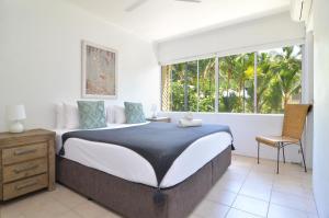 a bedroom with a large bed and a window at Seascape Holidays - Driftwood Mantaray in Port Douglas