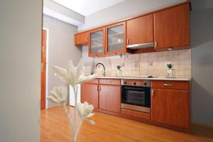 a kitchen with wooden cabinets and a flower in a vase at Palatinus Lake in Dorog