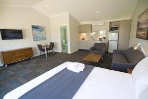 um quarto de hotel com uma cama e uma cozinha em Eastend Studio Apartments em Dubbo