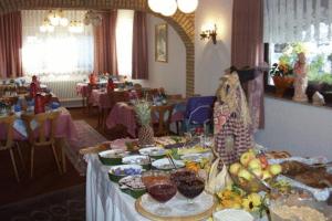 a long table with food on it in a restaurant at Hotel Wegis Garni in Bermatingen