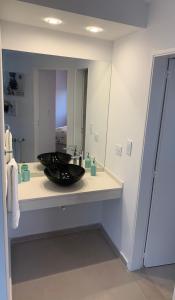 een badkamer met een wastafel en een spiegel bij MH Buona Vista in Monte Hermoso