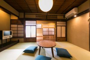 京都市にある染 SEN 五条一貫町 Gojo-Ikkannmachiのテーブル、椅子、テレビが備わる客室です。