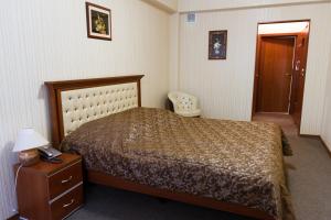 a bedroom with a bed and a table with a lamp at U Istoka Hotel in Irkutsk