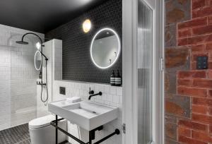 bagno con lavandino bianco e specchio di Farmers Home Hotel a Northam