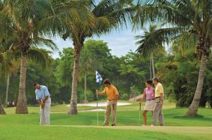 a group of people playing golf on a golf course at Holiday Inn Express & Suites Naples Downtown - 5th Avenue by IHG in Naples