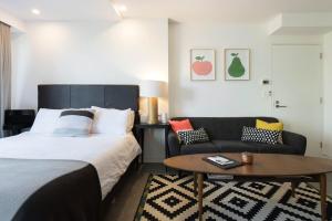 um quarto com uma cama e um sofá em Scandi Beach apartment em Avalon