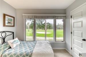 a bedroom with a bed and a large window at Fairway Oaks 1305 in Kiawah Island