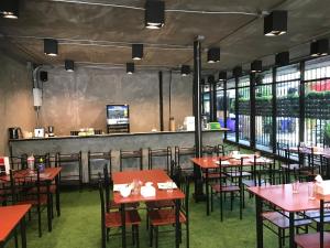 a dining room with red tables and chairs at My Loft Hotel SHA in Chiang Mai