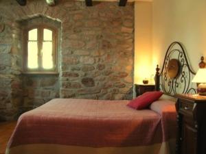 um quarto com uma cama e uma parede de pedra em Apartamentos Rurales Kastonea em Errazu