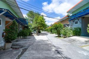 um passeio vazio entre dois edifícios com árvores em Ban Suan Chomdao Resort em Songkhla