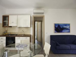 a kitchen with a glass table and a blue couch at Dolce Mare in Marina di Modica