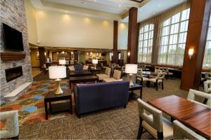 a hotel lobby with tables and chairs and a fireplace at Staybridge Suites - Newark - Fremont by IHG in Newark