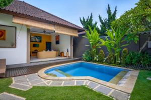 a swimming pool in the backyard of a villa at Gracia Bali Villas & Apartment in Seminyak