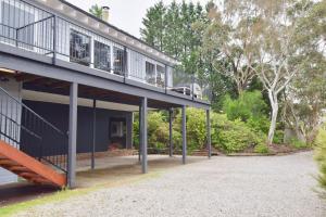 une maison avec un balcon et une allée. dans l'établissement Treetops Retreat Katoomba, à Katoomba