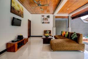 a living room with a couch and a tv at Gracia Bali Villas & Apartment by Manara in Seminyak