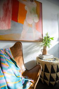 a chair in a room with a painting and a plant at RubyJune Inn in White Salmon