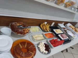 una tavola con molti tipi di cibo diversi di Hotel Villa da Penha a San Paolo