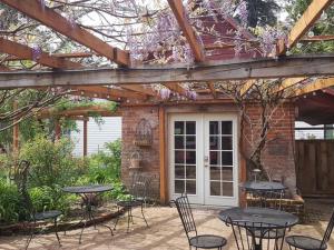 a patio with tables and chairs under a wooden pergola at RubyJune Inn in White Salmon