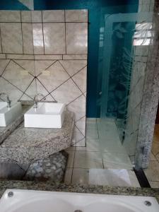 a bathroom with two sinks and a glass shower at Hotel Villa da Penha in Sao Paulo