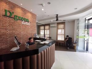 Un uomo seduto al bar in un ristorante di D'Green Hotel Kuching a Kuching