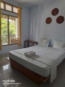 a bedroom with a bed with a towel on it at LilyPad guest house in Kuta Lombok