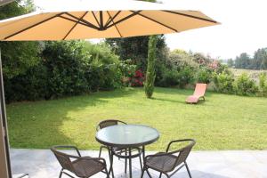 een tafel en stoelen onder een parasol op een patio bij E Cabanacce in Aléria