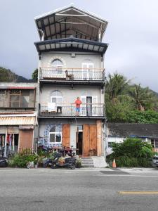 a man standing on a balcony of a building at Sleepy Buffalo in Donghe
