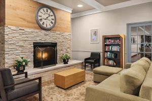 uma sala de estar com lareira e um relógio na parede em Country Inn & Suites by Radisson, Schaumburg, IL em Schaumburg