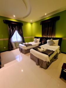 a room with two beds and a green wall at West Liberty in Jeddah