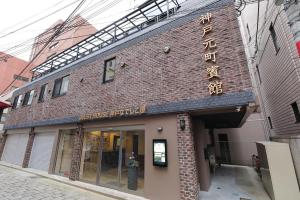 a brick building with a sign on the side of it at Guesthouse Kobe Nadeshikoya in Kobe